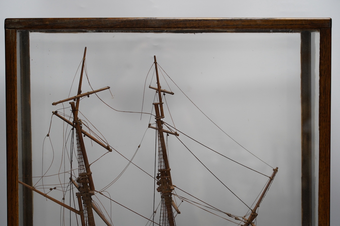 A glazed oak cased model of a ship, case 58cm tall. Condition - fair to good